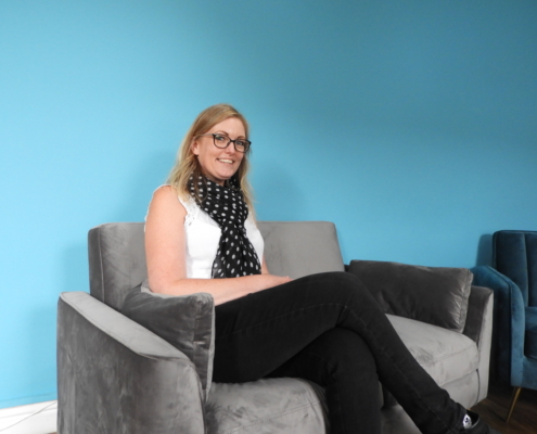 Woman sitting on couch blue background