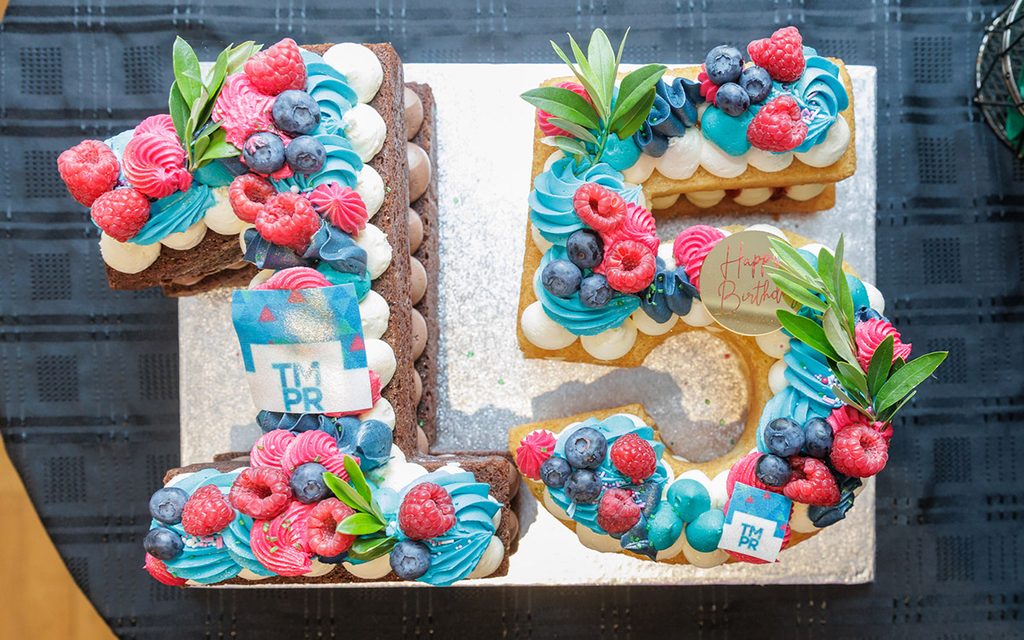 a cake shaped like the number fifteen topped with fresh fruit
