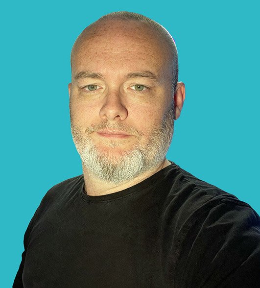 a headshot of Chris a man with a white beard